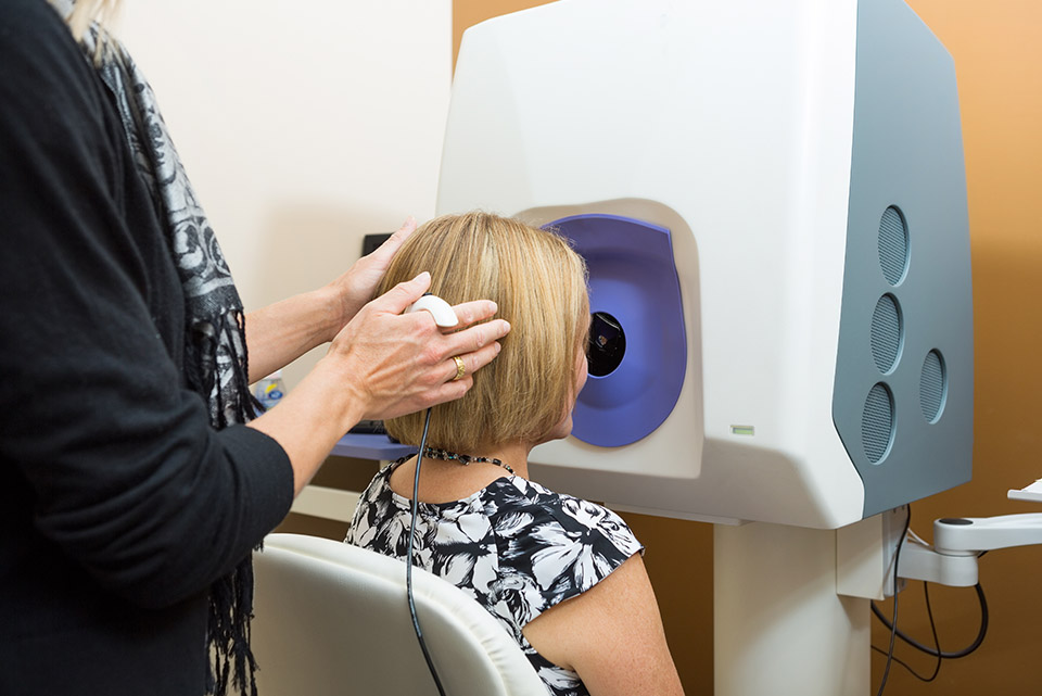 Optician Adjusting Patient's Head For Retinal Checkup